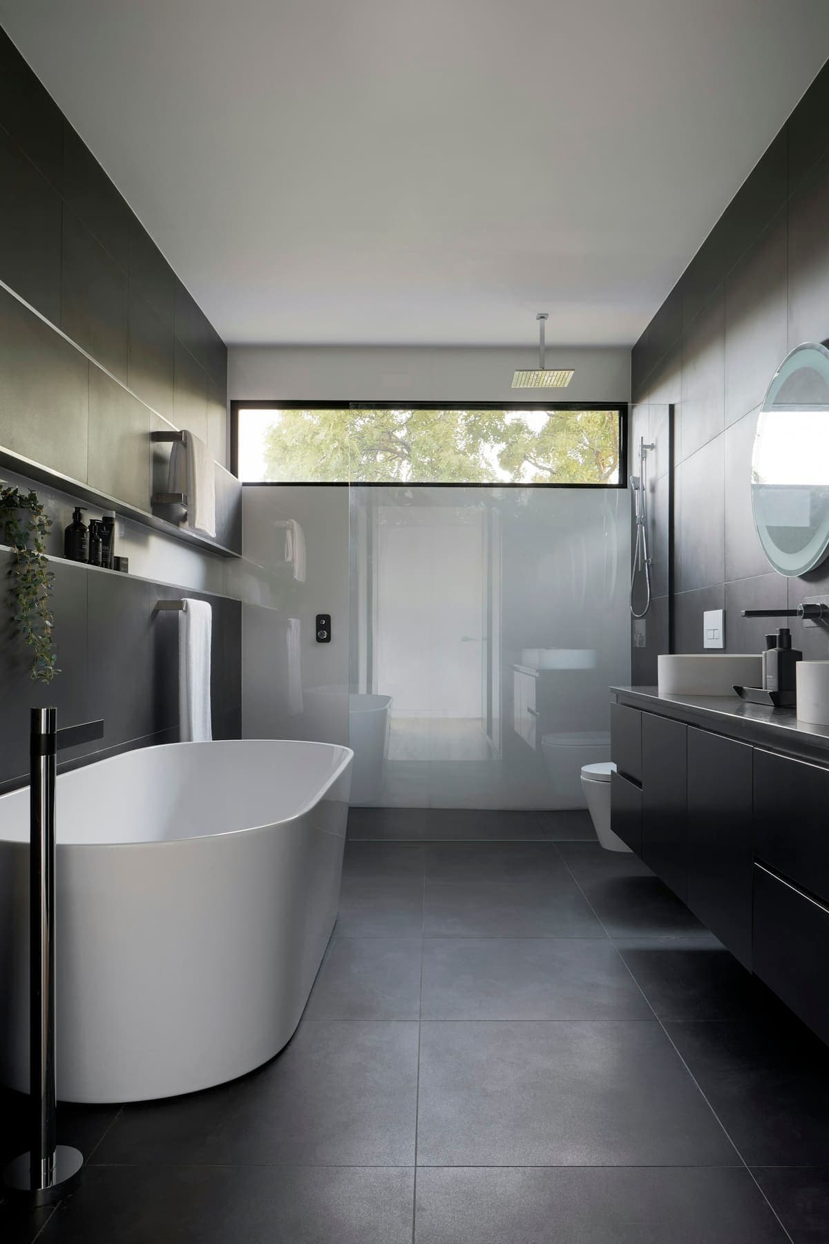 Gray tiled bathroom with a freestanding tub